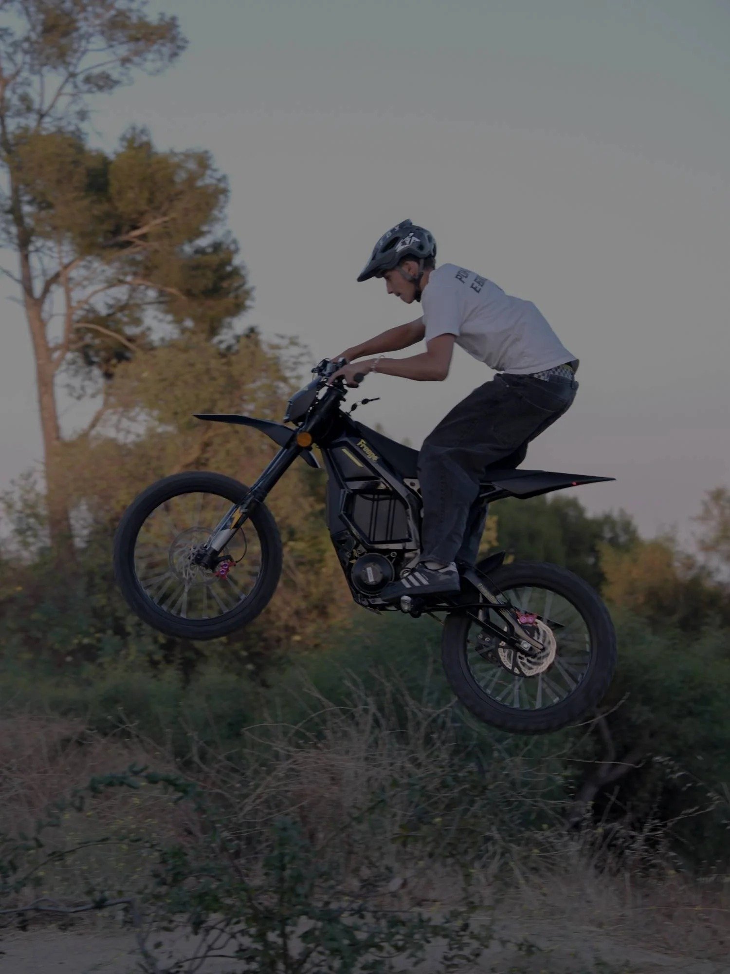 Portrait of rider jumping Freego Nova5 electric bike in dry hills